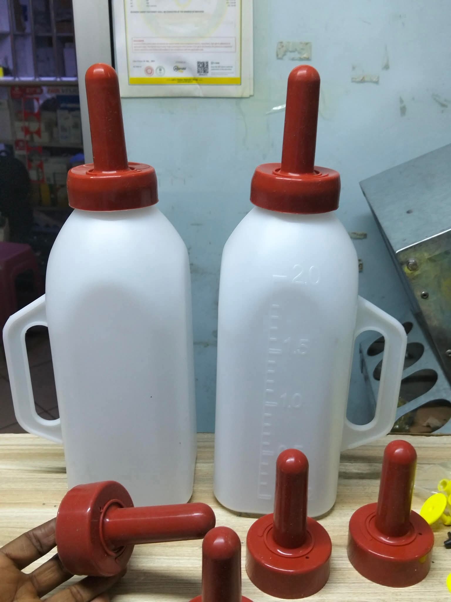 2 litre calf suckling feeding bottles with red rubber teats for feeding calves and young livestock